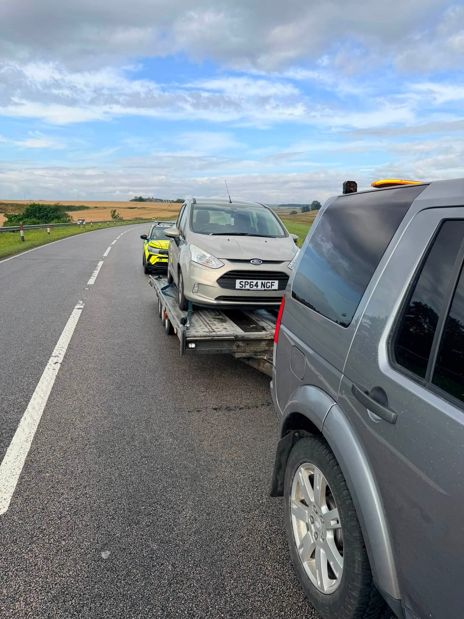 Ford secured on the DSBM transporter during a daytime roadside recovery